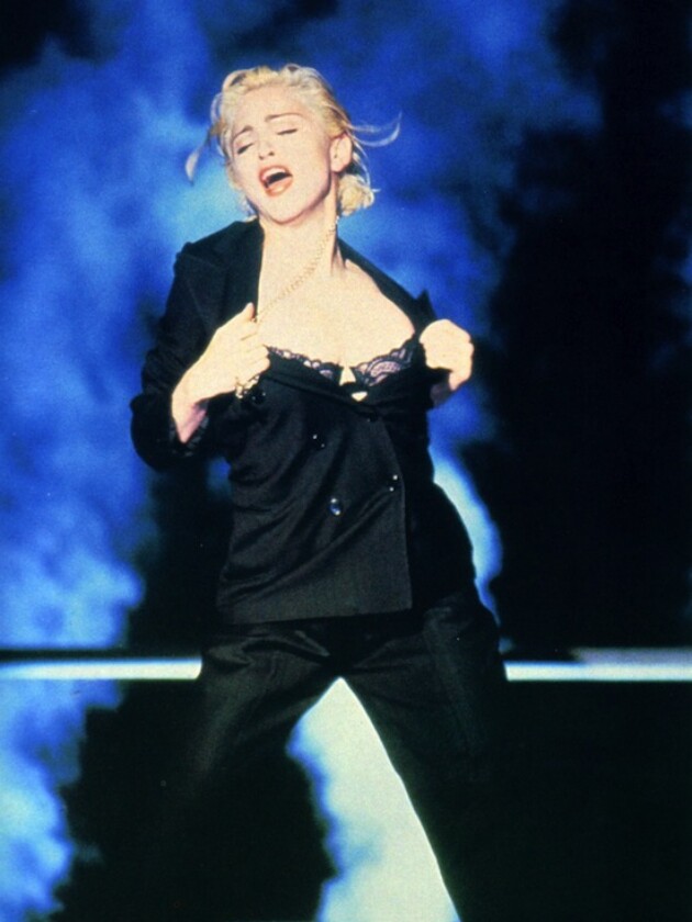 6 tendências de agora que Madonna adiantou décadas atrás Madonna usa blazer e calça de alfaiataria preta e sutiã à mostra no clipe de express yourself