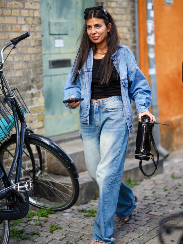 5 tendências de jeans para além do básico calça jeans oversized é usada com blusa preta justa e camisa jeans aberta