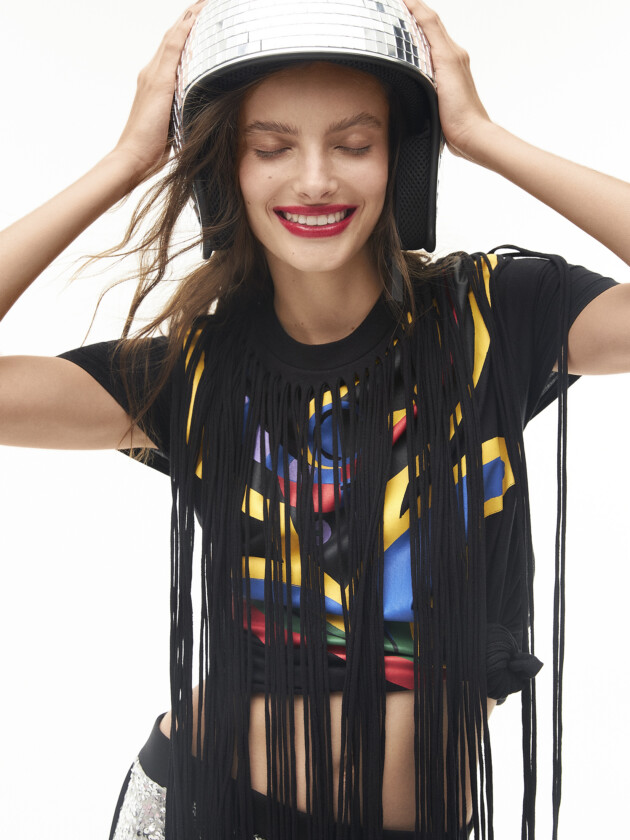 Vem ver os abadás do camarote da moda! mulher com camiseta preta com franjas compridas, do camarote Soma