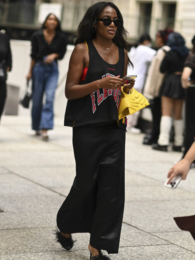 Como usar camisa de time: 5 dicas para incorporar a tendência esportiva Mulher usa camisa de basquete com saia acetinada e salto com plumas