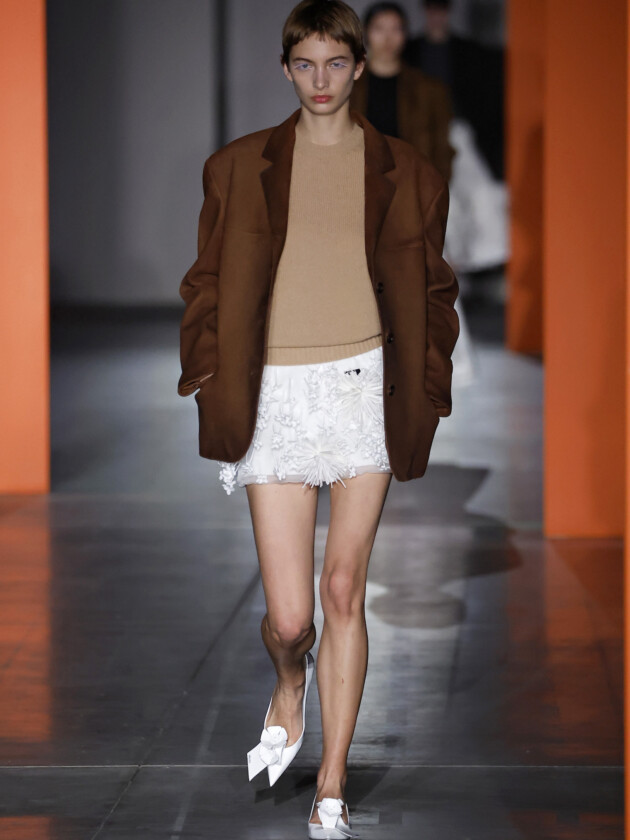 As principais tendências de minissaia da temporada Tendências de minissaia: saias com aplicações de flores aparecem no desfile de inverno 2023 da Prada. Aqui, modelo usa saia branca curta