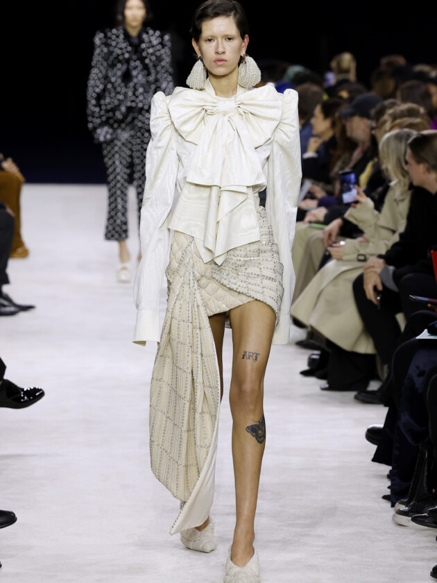 As principais tendências de minissaia da temporada Tendências de minissaia: saia branca curta com drapeado e tecido longo lateral é apresentado no inverno 2023 da balmain