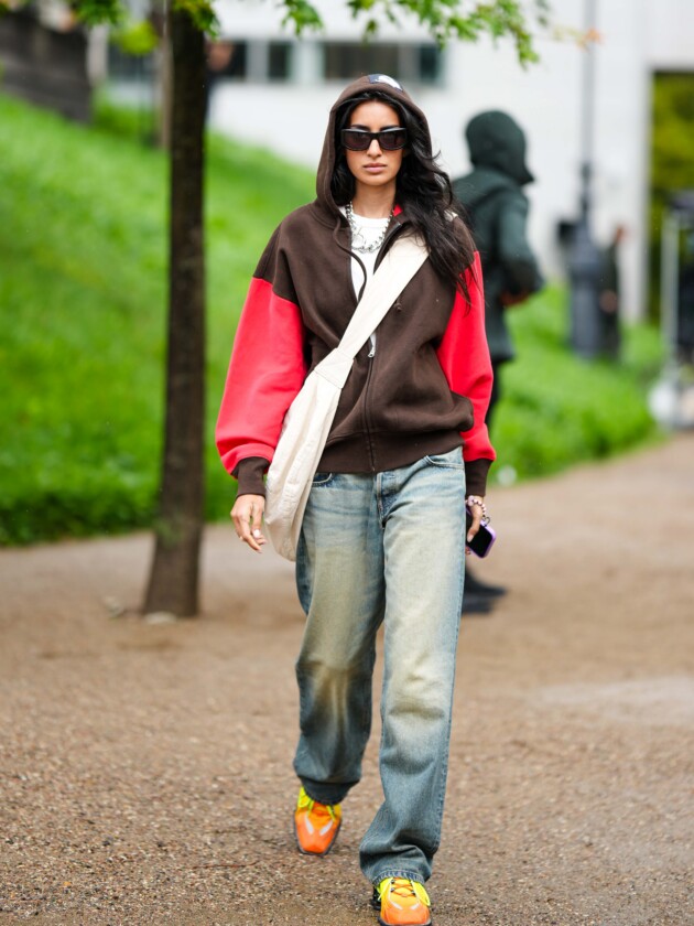 5 tendências de jeans para além do básico Jeans desbotoado é usado com moletom bicolor e bolsa transversal puffer