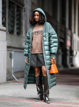 Os principais casacos e jaquetas do próximo inverno Mulher veste casaco acolchoado longo e verde e combina com botas hight knee e short