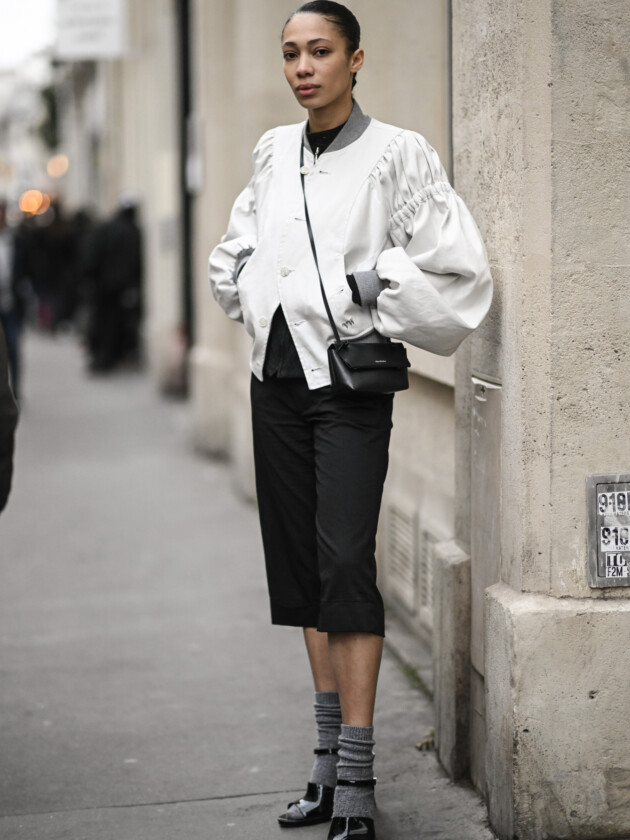 O retorno da calça capri: 5 maneiras de usar Modelo usa sapato com meia cinza em look com calça capri e jaqueta bomber