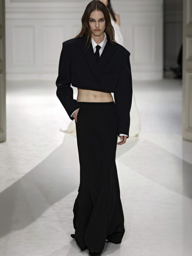 O boom dos conjuntos na moda: 10 estilos para ficar de olho A tendência dos conjuntos femininos: Modelo da Valetino Spring 2023 usa blazer cropped preto e saia longa de alfaiataria preta