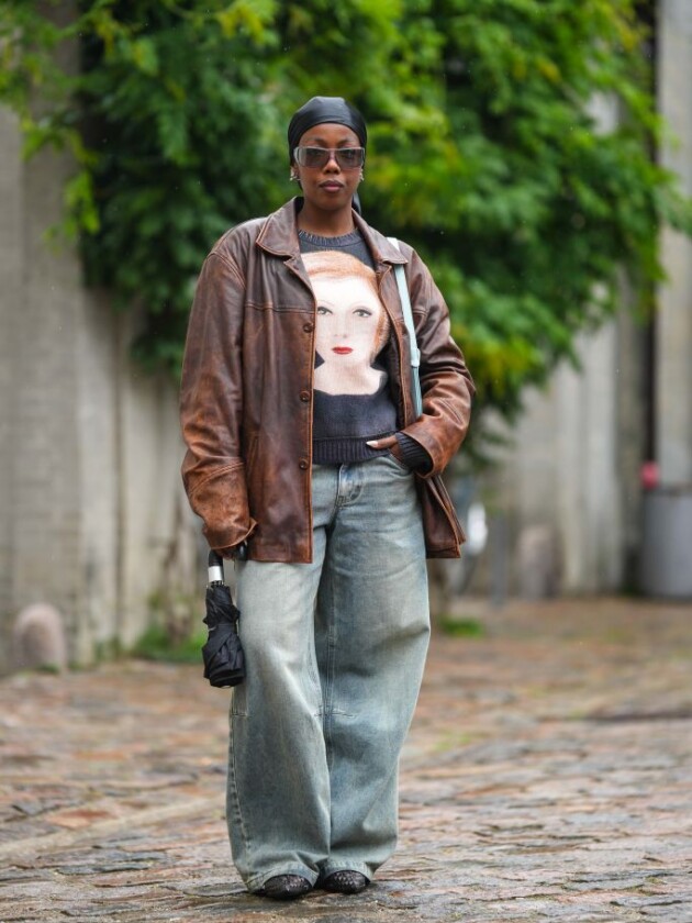 5 tendências de jeans para além do básico calça jeans oversized é usada com jaqueta de couro marrom