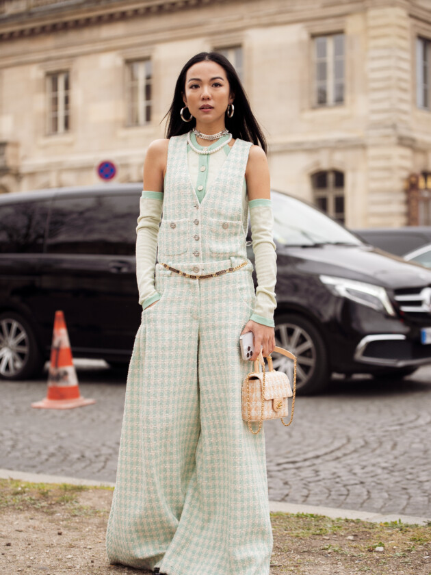 O boom dos conjuntos na moda: 10 estilos para ficar de olho A tendência dos conjuntos femininos: Mulher usa conjunto verde e branco com colete e calça pantalona da Chanel