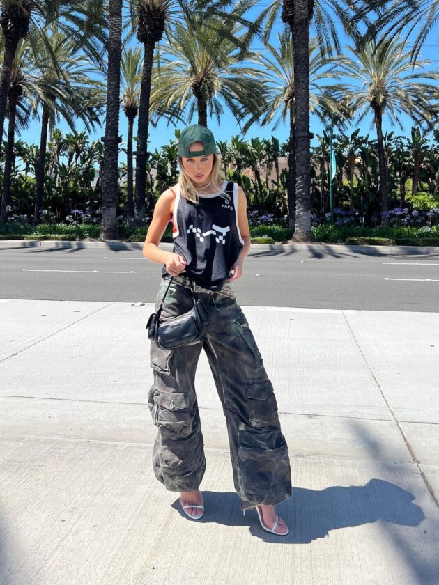 Como usar camisa de time: 5 dicas para incorporar a tendência esportiva Malu Borges usa camisa de basquete com saia cargo, boné e sandália de salto alto com tiras finas