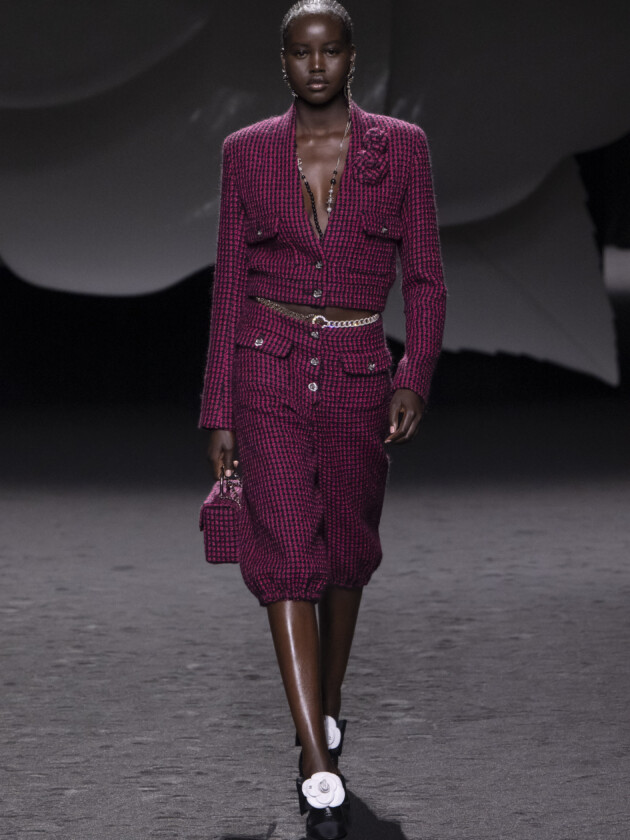 PARIS, FRANCE - MARCH 07: Adut Akech walks the runway during the Chanel Ready to Wear Fall/Winter 2023-2024 fashion show as part of the Paris Fashion Week on March 7, 2023 in Paris, France. (Photo by Victor VIRGILE/Gamma-Rapho via Getty Images) A tendência dos conjuntos femininos: Chanel apresenta tailleur rosa escuro com jaqueta cropped em seu inverno 2023