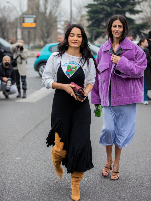7 ideias para atualizar o slip dress neste inverno O slip dress pode ir bem com um moletom. Aqui, Amina Muaddi coloca modelo cinza com estampa por debaixo de um slip dress preto e finaliza o look com botas caramelos