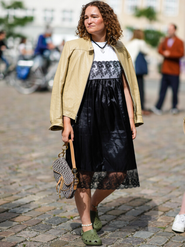 7 ideias para atualizar o slip dress neste inverno Mulher usa slip dress estilo camisola com camiseta branca por baixo e jaqueta bege por cima