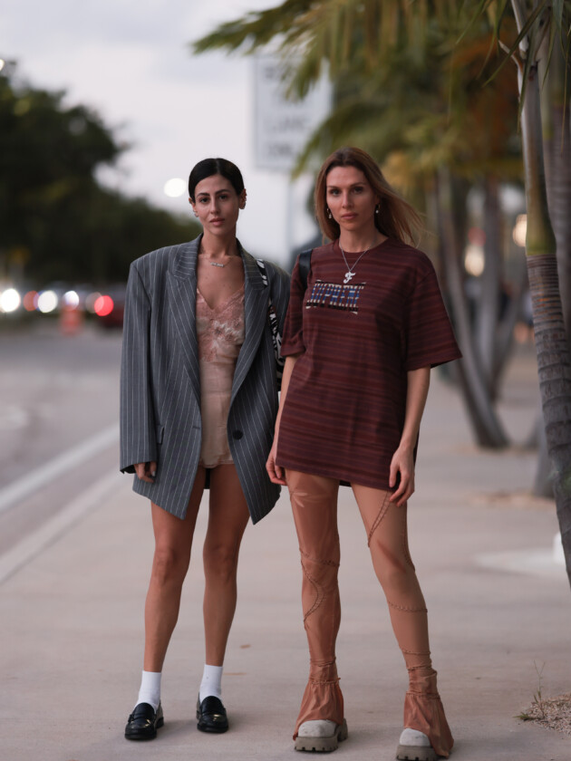 7 ideias para atualizar o slip dress neste inverno Gilda Ambrosio usa camisola bege e acetinada com detalhes de renda. A peça é usada no street style com blazer cinza oversized e mocassim preto com meia branca