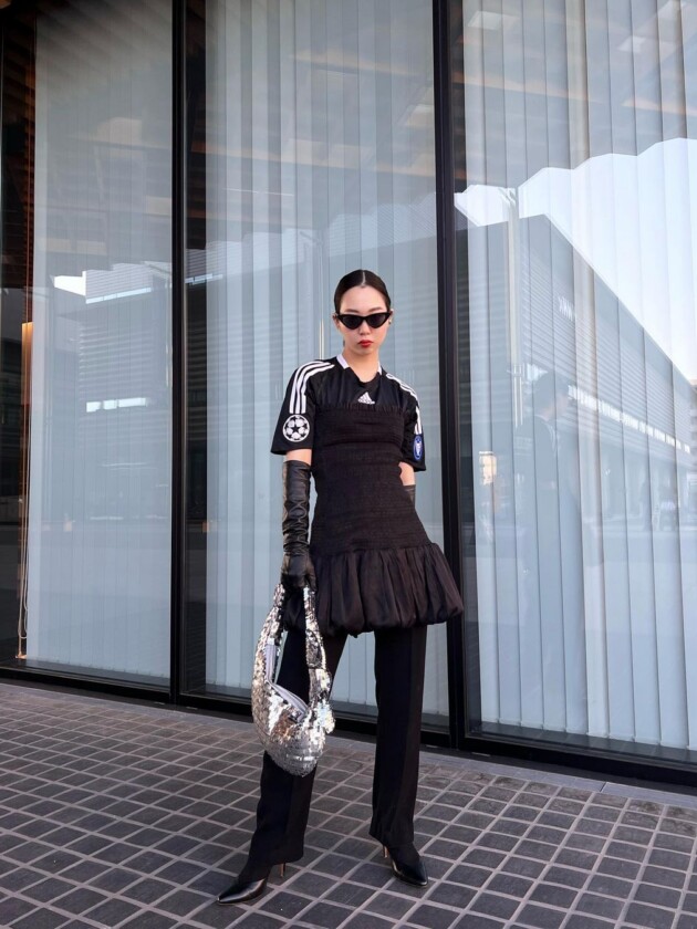 Como usar camisa de time: 5 dicas para incorporar a tendência esportiva Camisa de time é usada em look todo preto e sobreposta com vestido tomara que caia