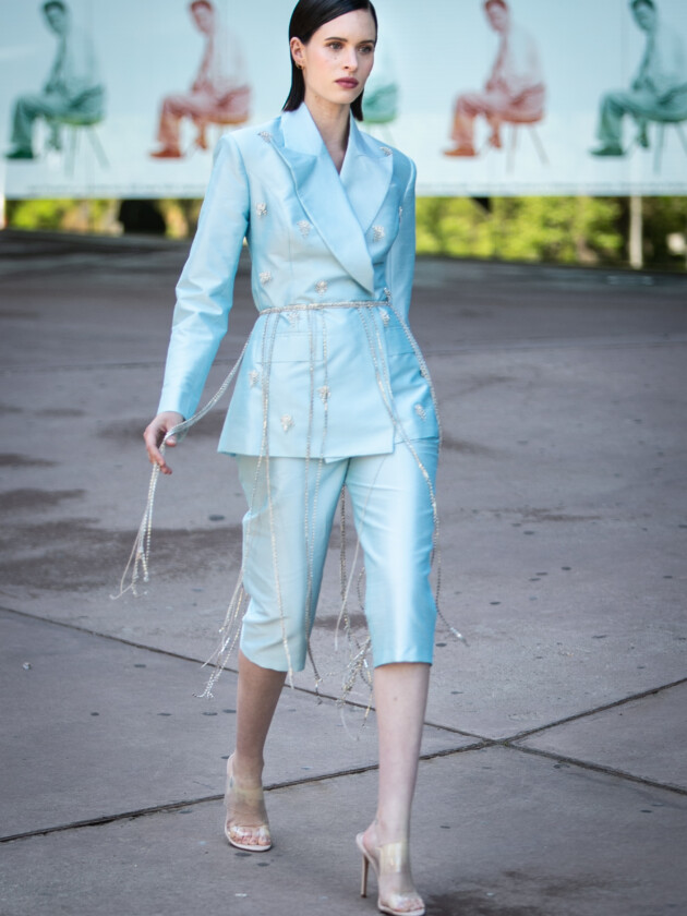 O retorno da calça capri: 5 maneiras de usar Mulher usa conjunto de blazer e calça social de corte capri na cor azul claro