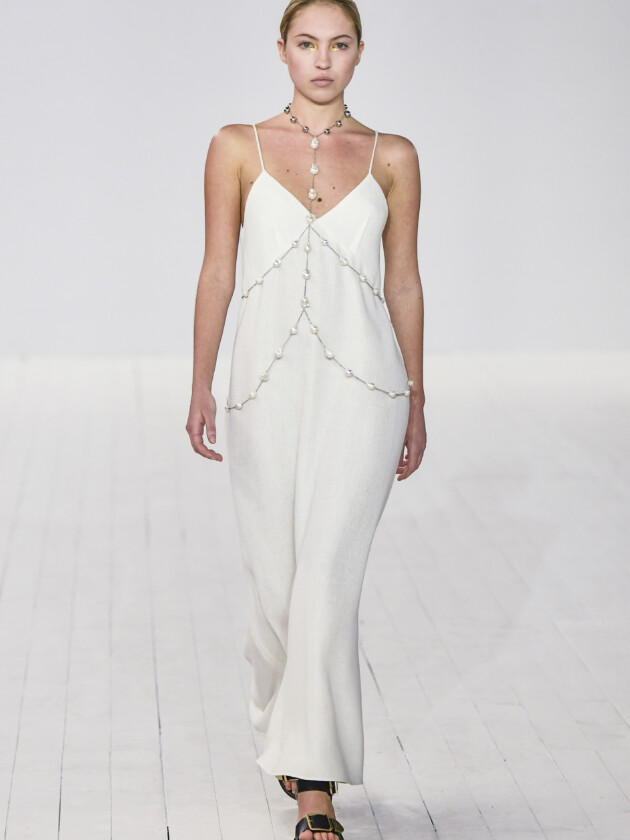 7 ideias para atualizar o slip dress neste inverno Desfile de invero 2023 da Chloé na semana de moda de paris (Paris Fashion Week) traz slip dress branco sendo complementado com body chain